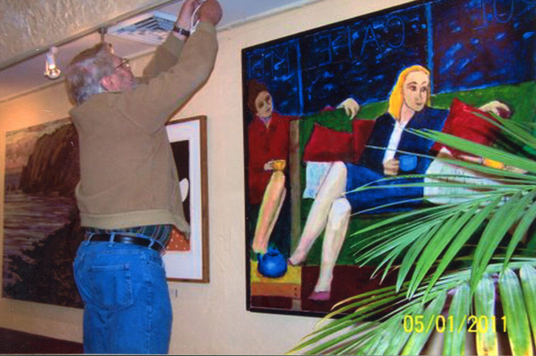 18j. At the Metropol. The owner George McGuinness is mounting the painting of three women.