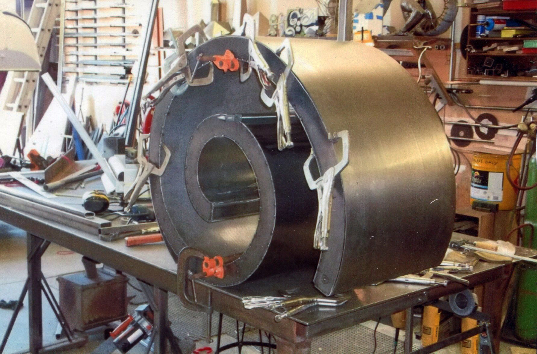 20e. Chandler’s shop. A spiral for the patio bench is on his work table.